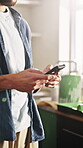 Typing, painter and hands with phone in kitchen, home renovation tutorial and internet search for tip. Remodeling research, man and mobile for makeover inspiration, interior design app and diy forum