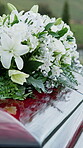 Casket, flowers and funeral in cemetery with burial ceremony, remembrance or death for final goodbye. Coffin, floral bouquet and memorial service in graveyard outdoor with honor, tribute or tradition