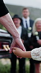 Person, holding hands and child at graveyard for funeral ceremony, burial service and mourning loss. Grandparent, family and kid with empathy, emotional ritual and condolences at farewell memorial