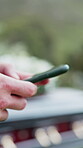 Funeral, digital and hands outdoor with phone, family arrangements or update on reception details. Typing, bokeh and person outside with tech, ceremony schedule or online chat at memorial service.