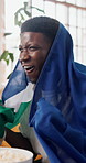 Celebration, Jamaica flag and streaming with black man on sofa as soccer or sports fan. Cheering, country pride and shouting with excited supporter in home living room for success or victory