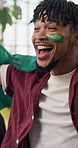 Celebration, flag of Brazil and shouting with black man on sofa as soccer or sports fan. Achievement, cheering and streaming with excited football supporter in home living room for success or victory