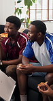 Friends, pizza and watching tv in home with sports fan, conversation and bonding together on weekend. People, eating fast food and talk in lounge with football broadcast, entertainment and hangout.