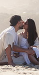 Couple, relax and kiss on beach with summer holiday, sunglasses and holding hands for bonding together. Happy, married people and affection by ocean with shades, vacation and discussion for travel.