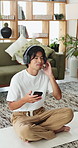 Man, phone and listening with headphones on yoga mat for audio therapy, playlist or stress relief. Calm, male person or relax with mobile smartphone or sound app for mental health or unwind in home