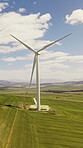 Countryside, wind turbine and renewable energy for sustainability, drone and eco friendly in nature. Grass field, windmill and natural resource with zero emissions in environment, outdoor and space