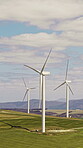 Green, wind turbine and renewable energy in countryside, drone or sustainability with zero emissions. Grass field, windmill and natural resource for carbon footprint in environment, space and outdoor
