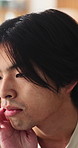 Sad, thinking and man in home, depression and mental health with loss, lonely and wonder. Apartment, emotion and Asian person in lounge, contemplation and reflection for nostalgia, grief and remember