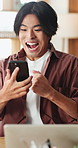 Excited, asian man and winning with phone in home for good news, online trading or profit. Happy, male person or freelancer with smile on mobile smartphone for investment, success or achievement