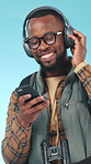 Headphones, hiker and dancing with phone in studio, streaming music or connection for travel holiday. Trekking vacation, smile or black man with tech for adventure playlist, groove or blue background