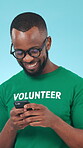 Volunteer, smile or black man with phone in studio, funny social media post or community service blog. Typing, laugh or eco advocate with mobile for ngo sign up site, recycle drive or blue background