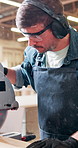 Man, carpenter and sawing machine in workshop for cutting wood, timber design and manufacturing. Male person, ppe gear or electric equipment for woodworking, carpentry repair and furniture production