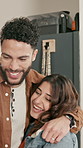 Win, couple and hug in home for celebration, goal achievement or excited for lottery. High five, man and woman in house for victory, financial freedom and embrace with happy partner for success