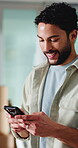 Man, smile and typing in office with phone, email notification and website for business communication. Happy, person and text message in workplace with tech, online chat and social media for company.