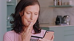 Woman, thinking and credit card in home with phone, website or contemplation for online shopping sale. Mature person, tech and reflection in house with digital banking, ecommerce purchase or decision