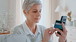 Senior, woman and credit card with phone for online shopping, payment or banking app in home. Elderly, female person or shopper with debit on mobile smartphone for wireless transaction or gift card
