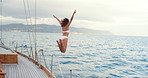 Travel, jump and woman on yacht in ocean for summer holiday, vacation and tropical adventure. Space, tourism and person in sea for swimming, freedom and fun on luxury cruise, trip and explore island