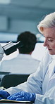 Microscope, woman and scientist in laboratory for writing notes with medical research, study or project. Biotechnology, professional and mature female biologist with pharmaceutical breakthrough.