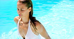Thinking, woman and walk in swimming pool at resort for travel, peace and summer holiday. Female person, water and swimwear with reflection, getaway activity and stress relief at vacation destination