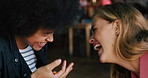 Happy women, laughing and playing with food in cafe for funny joke, goofy or bonding together. Female people, friends or throw with silly catch, feeding or eating for humor at indoor restaurant