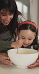 Mother, girl or mixing with bowl in kitchen, teaching cooking skills or talking for breakfast preparation. Instructions, happy woman or child with support for baking, learn or bonding in family home