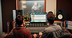 Production, music and back of producers with headphones in studio working on album or song with computer. DJ, equipment and male sound technicians with technology for mixing audio in recording booth.