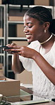 Boxes, supply chain and black woman with cellphone for picture, online review and qr code. Entrepreneur, business owner and person in office, smartphone for photography or delivery info for product