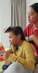 Hairbrush, mother and reading book with girl in home, morning routine and childcare for connection. Bonding, happy woman and child with hair care for grooming, fairytale or speaking for learning help