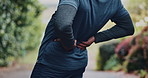 Man, runner or back pain with fitness injury for discomfort, strain or overworked stress in nature. Male person, athlete or sore spine with inflammation or ache for muscle tension or outdoor accident
