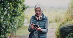 Phone, fitness and senior woman in nature with texting, networking or contact on mobile app. Technology, workout and elderly female person with cellphone for chat online outdoor in park in morning.