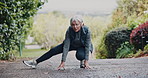 Stretching, outdoor and old woman with exercise, wellness and headphones for audio, nature and workout. Runner, training or mature person with fitness, warm up for health benefits and listen to radio