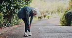 Stretching, outdoor and old woman with exercise, morning and headphones for audio, nature and workout. Runner, training or mature person with wellness, fitness for health benefits and listen to radio