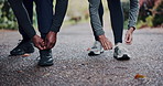 Fitness, nature and couple tying laces for workout, training or running outdoor in park for wellness. Sports, sneakers and hands of people preparing for cardio exercise, health or active outdoor.