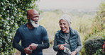 Senior, people and walking with water bottle in nature for workout break, exercise or rest together. Interracial couple, elderly man and woman strolling with mineral liquid for recovery or hydration