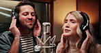 Microphone, singing and musicians in studio with headphones for recording music, song or album. People, creative talent and man with woman for production of audio track together in sound booth.