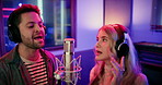 Microphone, singing and singers in studio with headphones for recording music, song or album. Musicians, creative talent and man with woman for production of audio track together in sound booth.