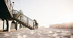 Headphones, man and running on stairs at beach for HIIT workout, endurance challenge or fitness. Mockup space, athlete or cardio on steps outdoor for athletic performance, exercise routine and music