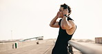 Fitness, happy and man with headphones in city for training, exercise and workout for wellness. Rest, road and person on break for recovery, health and tired for challenge, sports and listen to audio