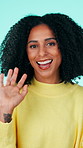 Happy woman, face and wave with introduction in studio for hello or greeting on a blue background. Portrait, female person or model with smile, vlogger or influencer for goodbye, farewell or gesture