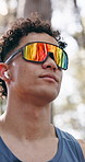Fitness, man and sightseeing forest with sunglasses for workout break, health podcast or bokeh. Eyewear, happy athlete and explore woods with earphones for exercise rest, nature appreciation or music