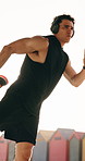 Beach, stretching and man with headphones for fitness, exercise or listening to podcast for wellness. Outdoor, athlete and person with workout for health, flare and streaming audio with technology