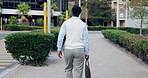 Walking, city and back of business man in street for morning commute, travel and journey. Pedestrian, corporate and African person on trip for work, career and professional opportunity in town