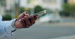 Phone, waiting and hands of businessman in city for travel, cab or taxi on mobile app for commuting. Technology, scrolling and male employee with cellphone for car service at location in urban town.