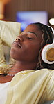 Relax, stretching and black woman with headphones on sofa, mindfulness audio guide and streaming music. Rest, listen and happy person with meditation track for stress relief, peace and tech in home
