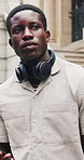 Black man, phone and typing with waiting in city, ride share app or directions with headphones for travel. Person, checking and online request on mobile chat for ehailing service with commute in town