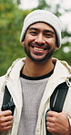 Hiking, face and happy man on break in nature for adventure, travel and laughing on winter vacation. Outdoor, exploration and person with smile on holiday, backpacking and hiker on getaway in woods