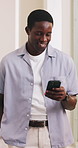 Creative, happy and black man with phone in office for social networking, marketing campaign or online chat. Startup, media agency and person laugh on cellphone for conversation, contact and internet