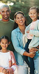 Happy family, face and holiday with children in nature for outdoor weekend or bonding together. Portrait, mom and dad with kids, smile or love for fun trip, parenthood or childhood in park or woods