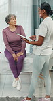 Senior, woman and physiotherapist in clinic with clipboard, discussion and update for rehabilitation. Elderly person, healthcare worker and talk with checklist, physical therapy and medical report.