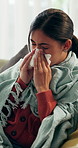 Sick, sneeze and woman in living room with tissue, influenza and cold congestion in allergy season. Health, virus and person in house with paper napkin, blowing nose and viral flu in wellness risk.
